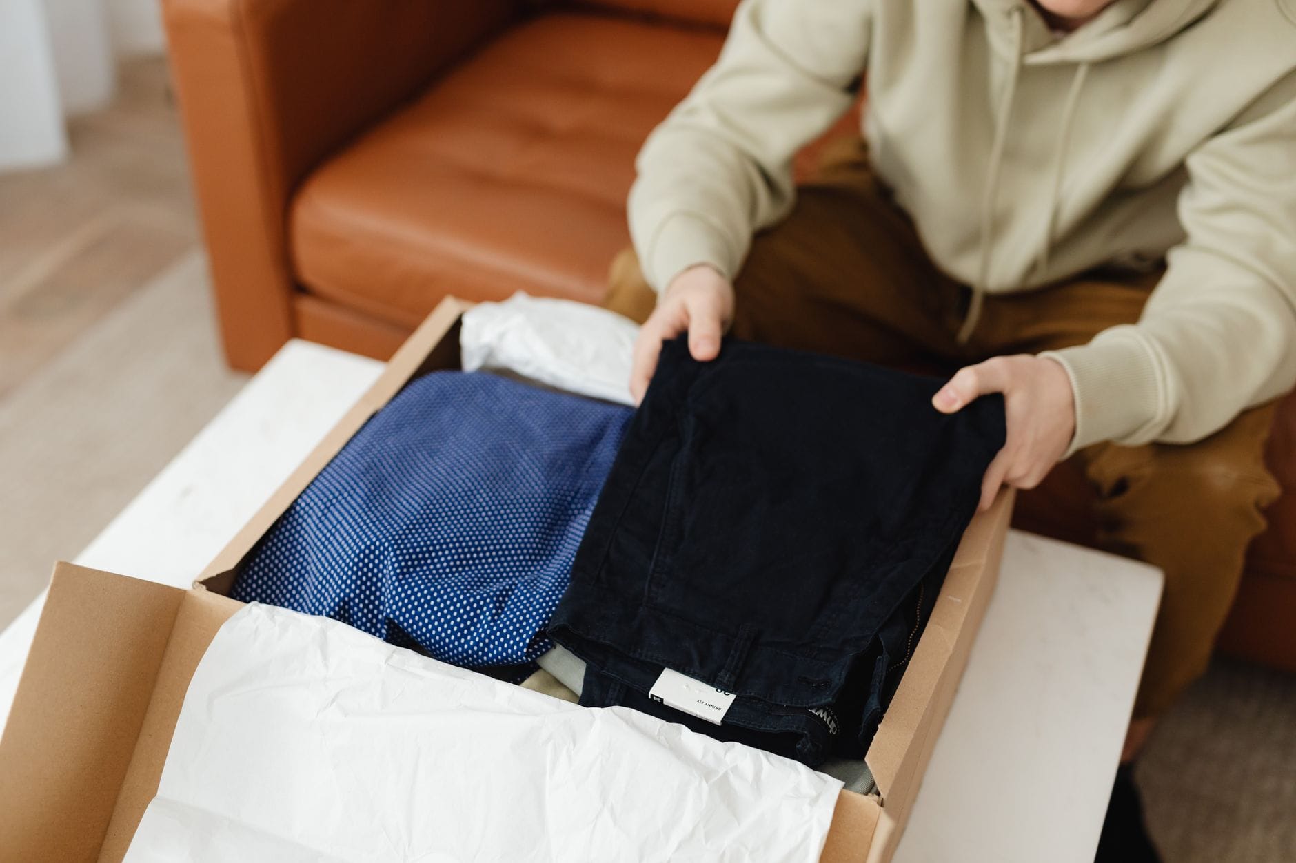 Mężczyzna wyjmuje nowe ubrania z kartonu podczas unboxingu