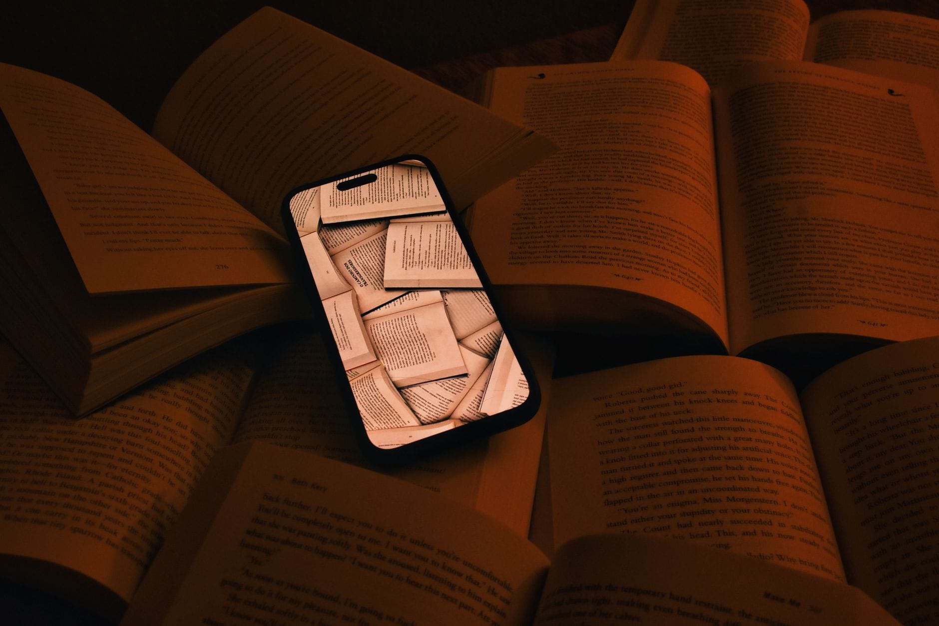 Smartfon z wyświetlonym PDF wśród otwartych książek